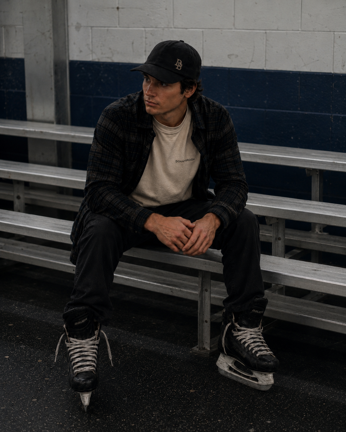 Donnybrook lifestyle — rink bench in skates, flannel and DB cap